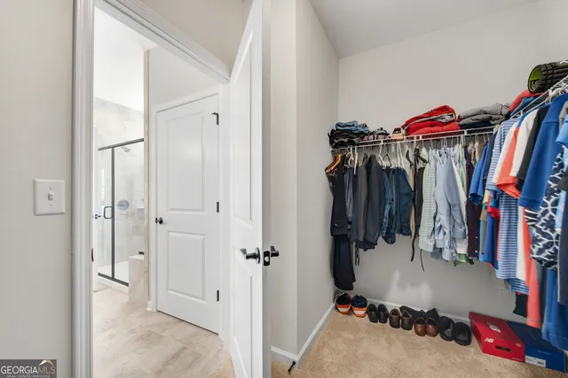 a view of walk in closet with clothes