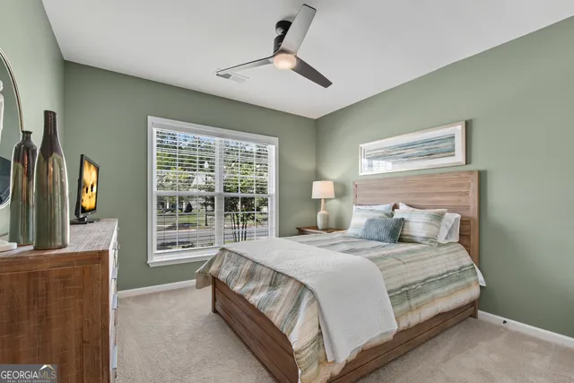 a bedroom with a large bed and a flat tv screen on dresser