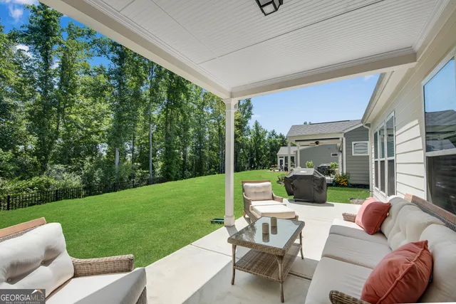 a view of a patio with couches chairs and a big yard