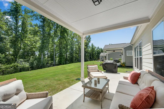 a view of a patio with couches chairs and a yard