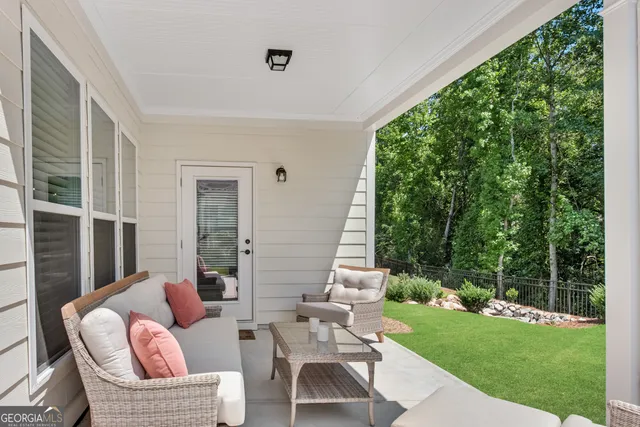 a view of a patio with couches chairs and a yard