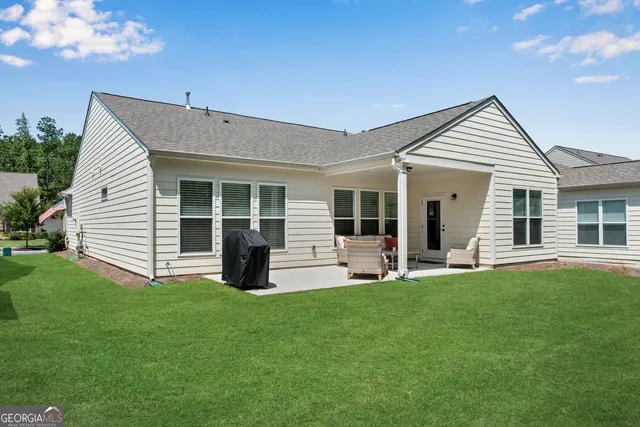a view of a house with a yard and sitting area