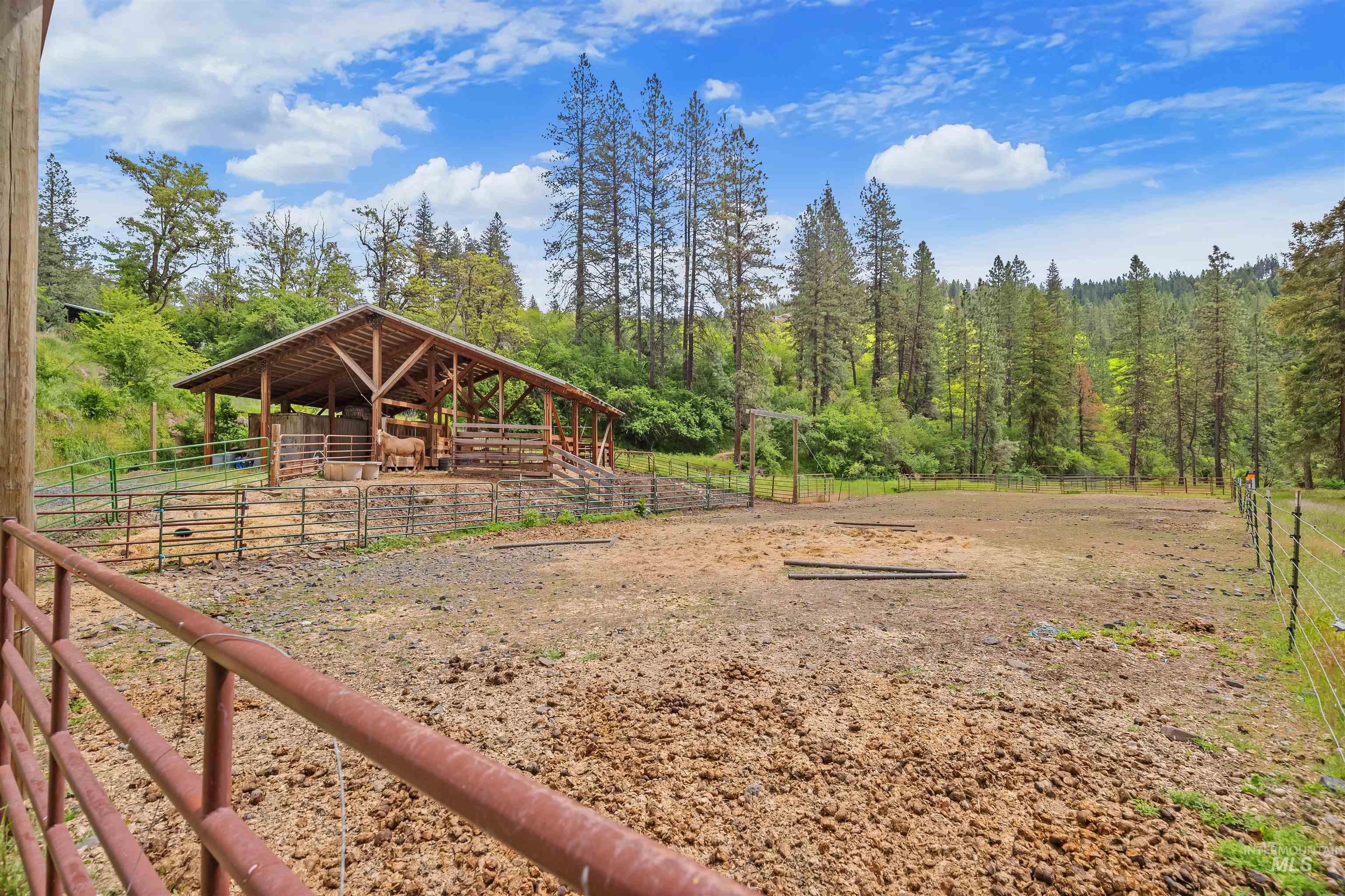 1314 Cedar Ridge Road Kendrick, ID 83537 - Photo 40 of 50 Expansive agricultural land featuring a robust open-air barn with natural wood construction, secured by sturdy fencing