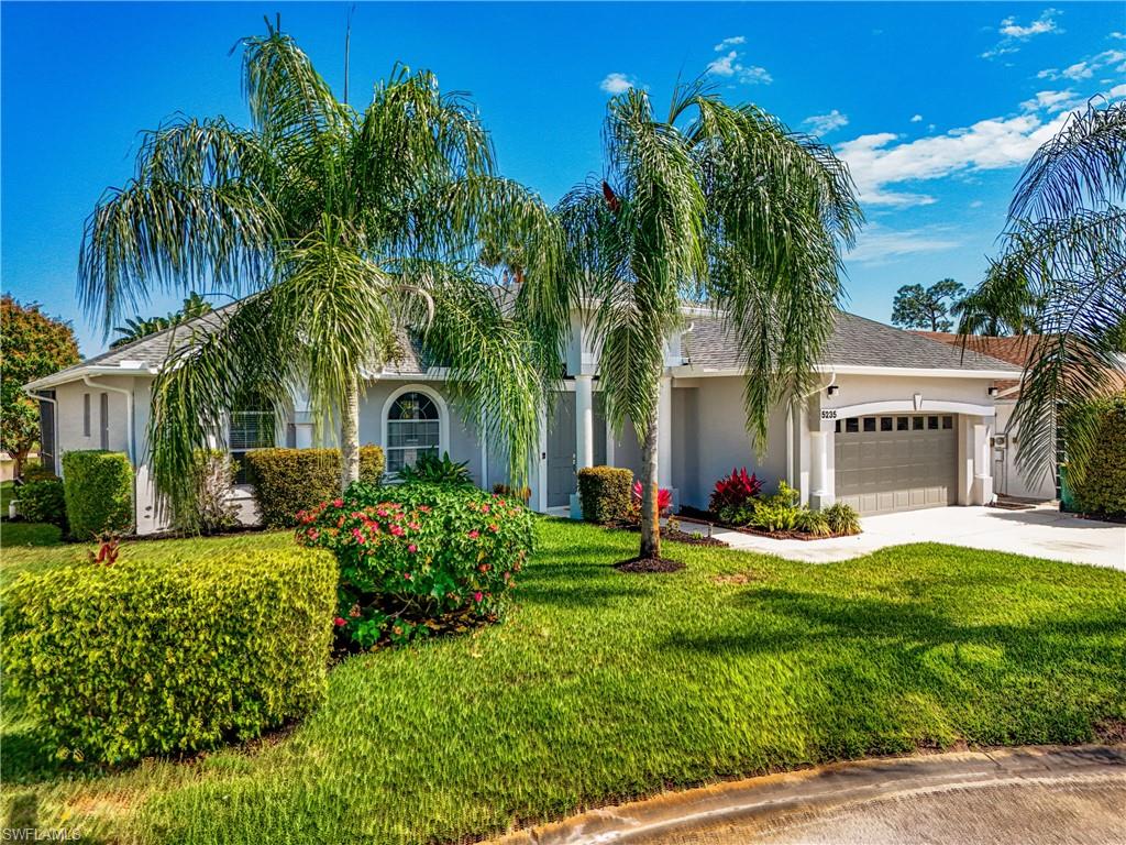 5235 Malvern Court Naples, FL 34112 - Photo 1 of 28 a front view of a house with garden and trees