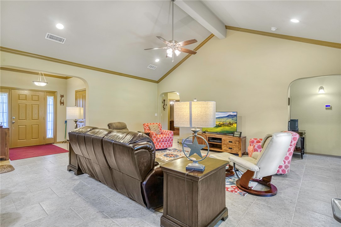 9945 Oxford Cemetery Road Madisonville, TX 77864 - Photo 8 of 42 Living room with arched walkways, crown molding, beamed ceiling, high vaulted ceiling, and recessed lighting