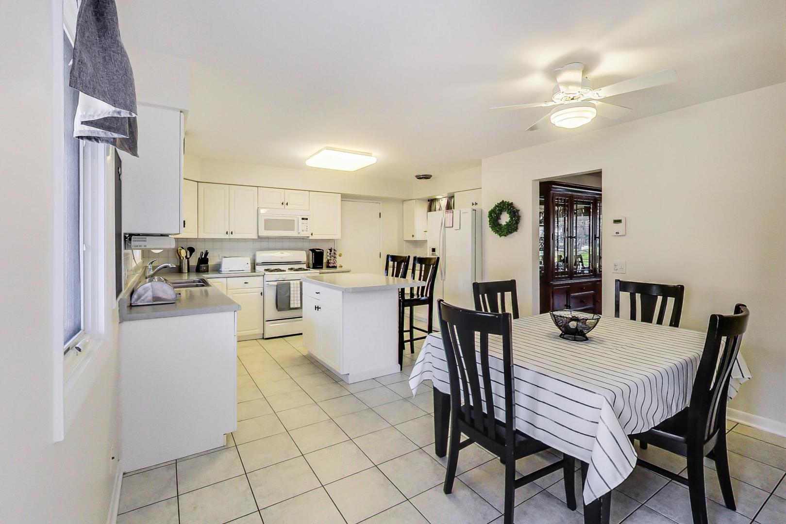 3018 Farrell Avenue Park Ridge, IL 60068 - Photo 9 of 34 a kitchen with a dining table chairs and refrigerator