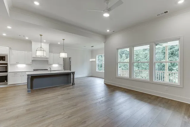 a view of a kitchen with kitchen island a sink stainless steel appliances and a chandelier