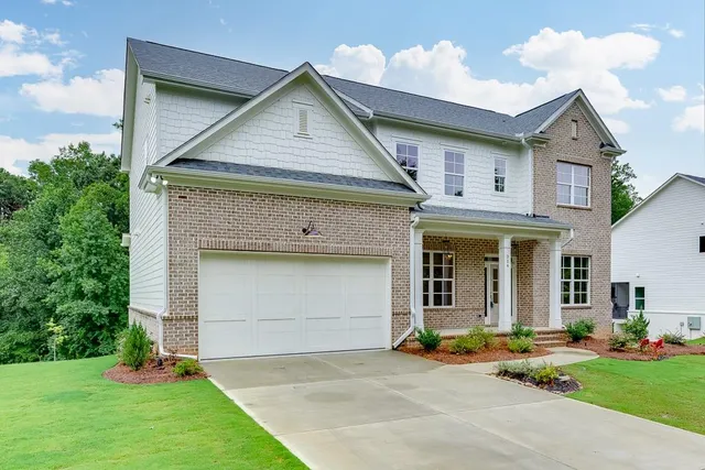 a front view of a house with a yard and garage