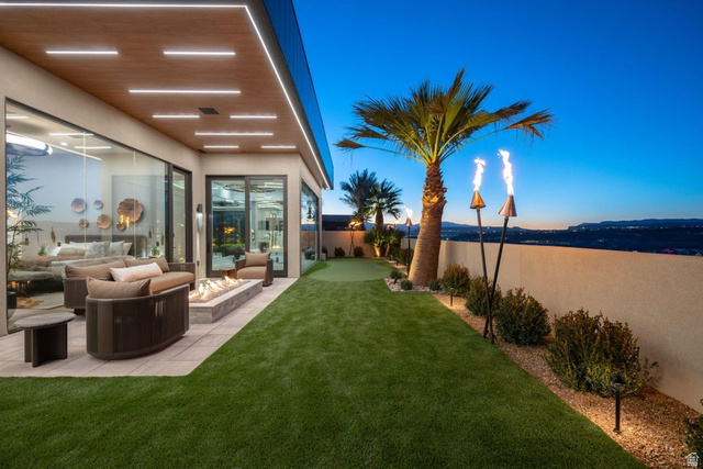 2867 East Granite Way St. George, UT 84790 - Photo 65 of 69 Outdoor living space featuring an expansive patio, built-in fire pit, artificial turf, and mature landscaping
