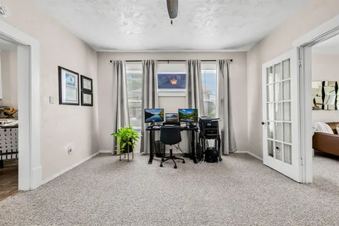 a view of a livingroom with workspace and a window