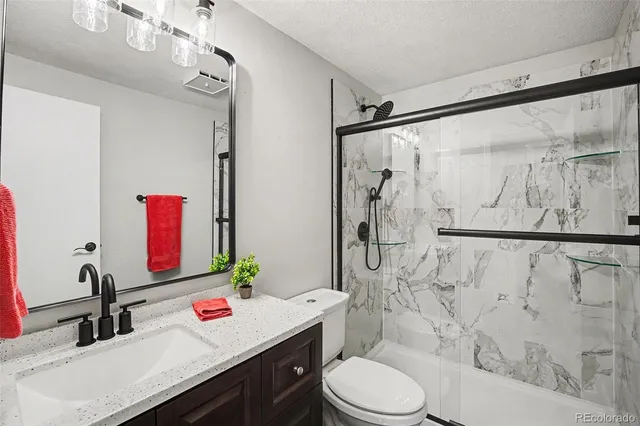 a bathroom with a sink vanity mirror and toilet