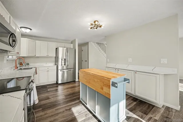 a kitchen with a stove a refrigerator and a sink