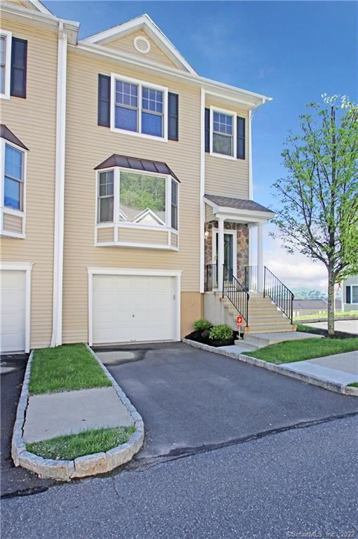 15 Scuppo Road, Unit 1004 Danbury, CT 06811 - Photo 1 of 1 a front view of a house with a yard and garage