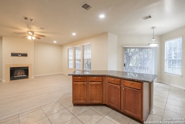 a large kitchen with granite countertop a stove sink and cabinets
