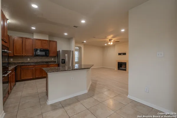 a large kitchen with stainless steel appliances a sink a stove a microwave and a refrigerator