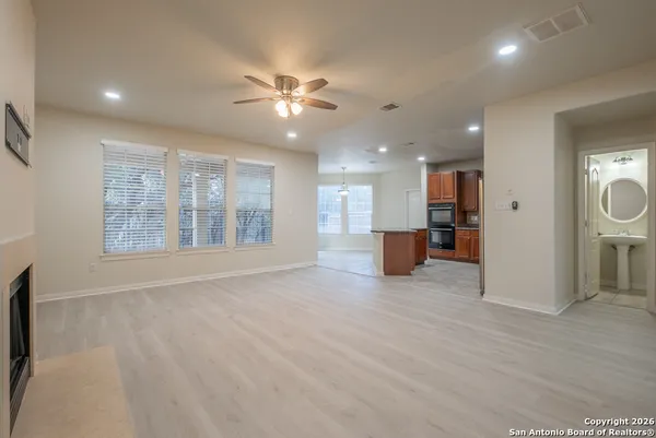 a view of an empty room with a window and wooden floor