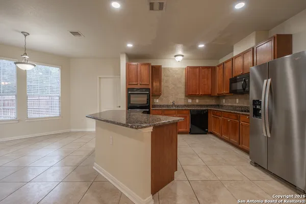 a kitchen with stainless steel appliances granite countertop a stove a sink and a refrigerator