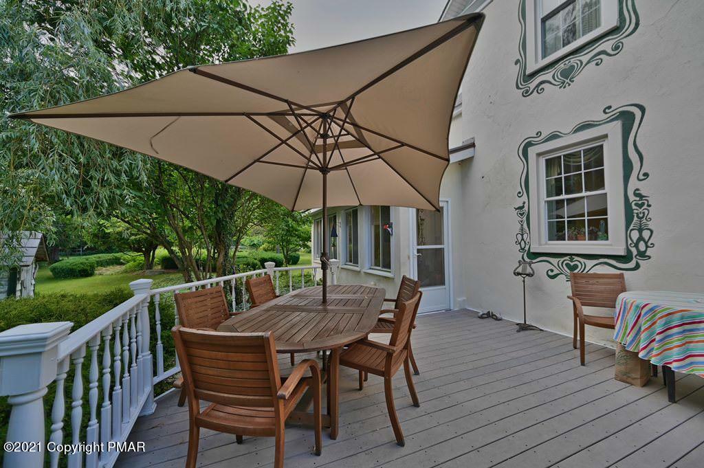 259 Hay Road Stroudsburg, PA 18360 - Photo 64 of 137 a patio with wooden floor a yard a table and chairs