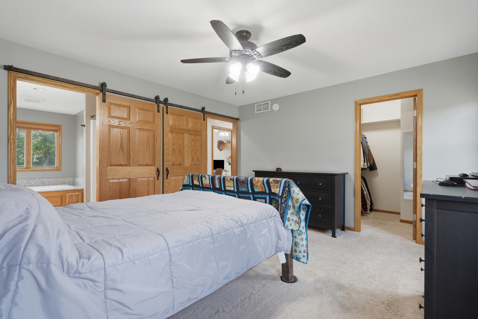2237 Hickory Hills Road Muscatine, IA 52761 - Photo 12 of 53 a bedroom with a bed and a chandelier