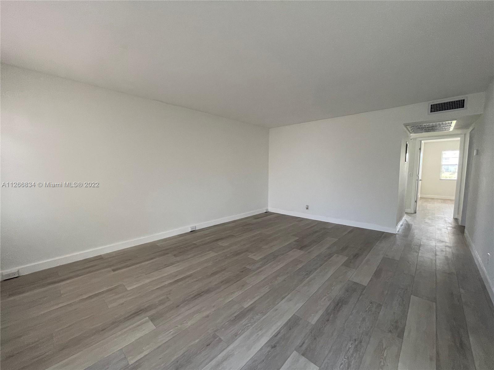 1084 Guildford East Boca Raton, FL 33434 - Photo 14 of 34 a view of empty room with wooden floor and fan