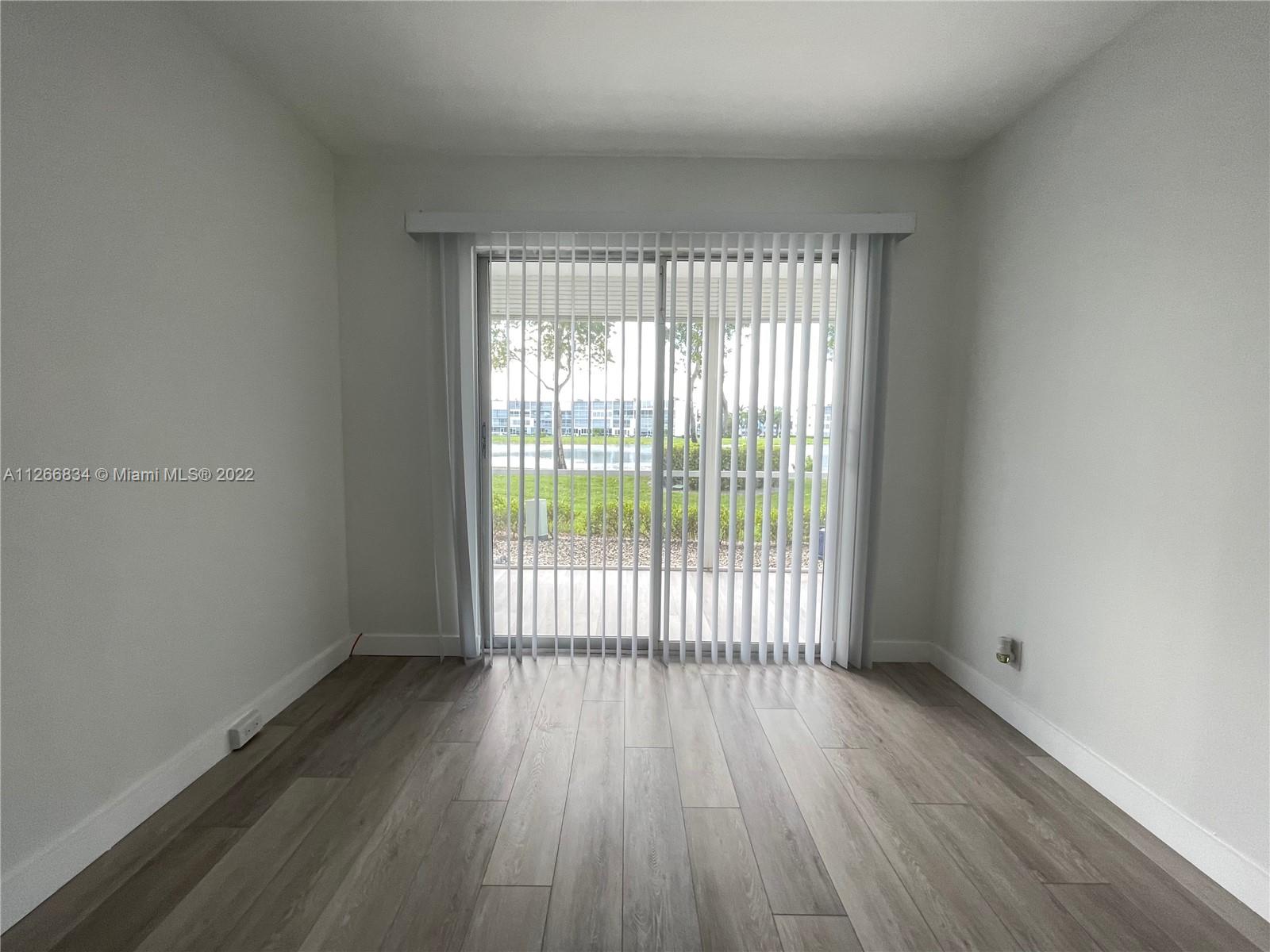 1084 Guildford East Boca Raton, FL 33434 - Photo 18 of 34 wooden floor in an empty room with a window
