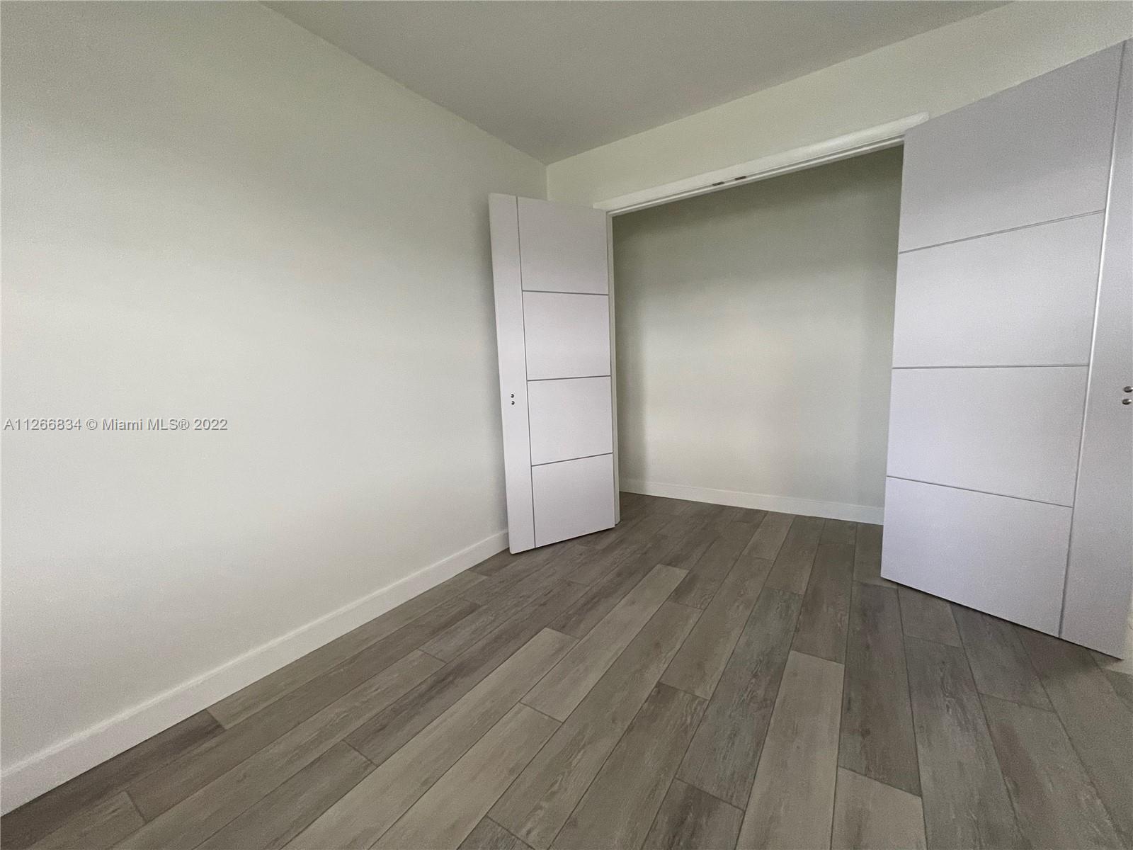 1084 Guildford East Boca Raton, FL 33434 - Photo 19 of 34 an empty room with wooden floor