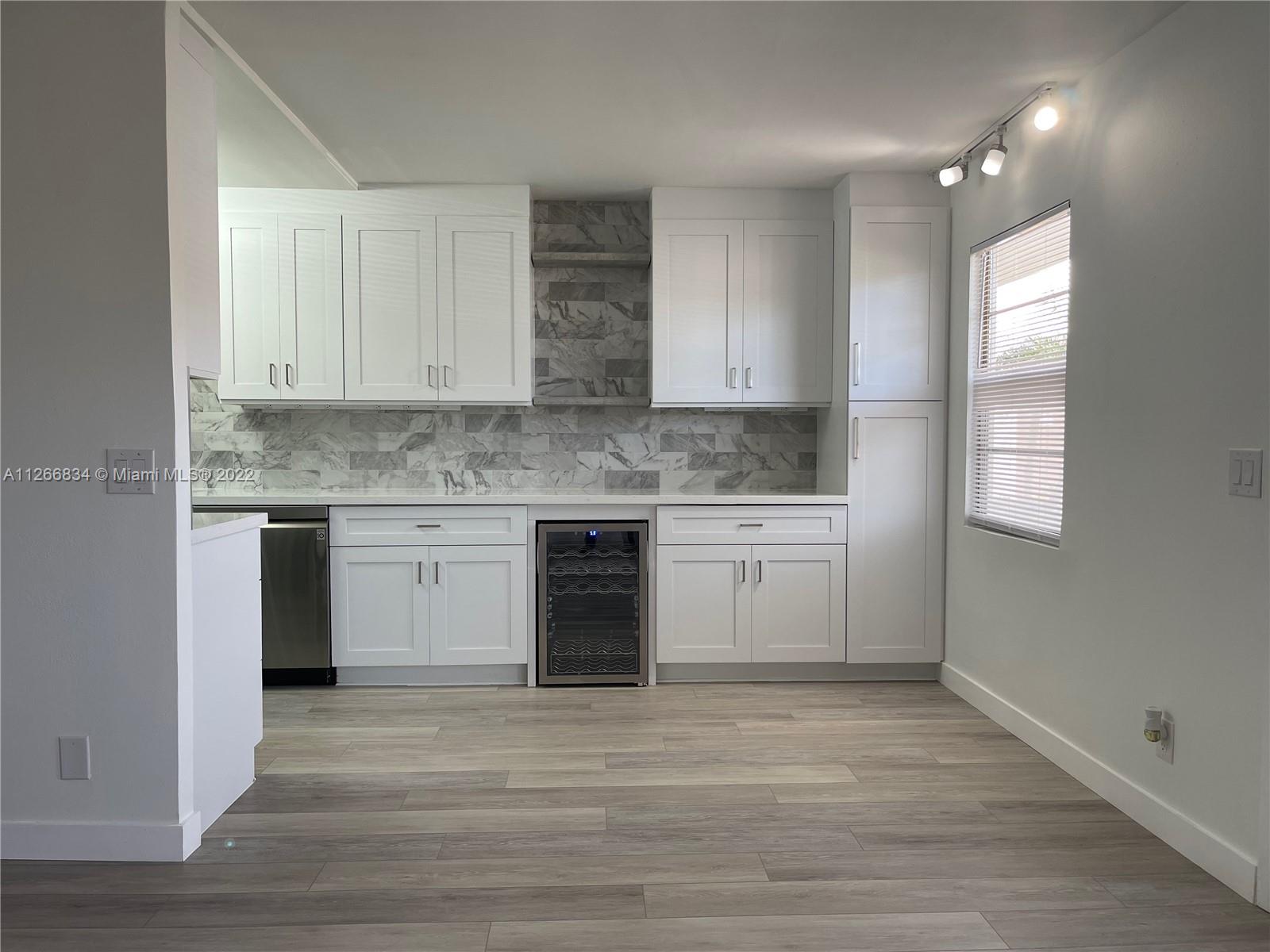 1084 Guildford East Boca Raton, FL 33434 - Photo 9 of 34 a kitchen with a white cabinets and window