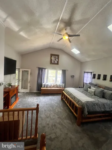 a spacious bedroom with a bed and a flat screen tv