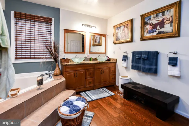 a spacious bathroom with a tub sink and a mirror