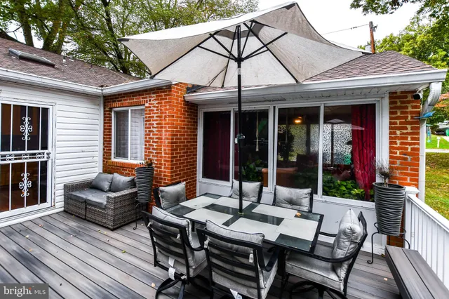 a view of a patio with a dining table and chairs with wooden floor and fence