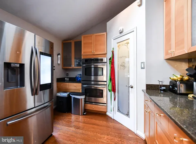 a kitchen with stainless steel appliances granite countertop a refrigerator and a sink