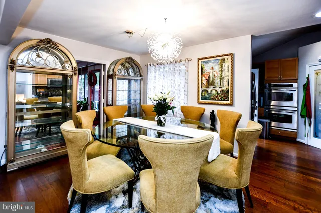 a dining room with furniture a chandelier and wooden floor