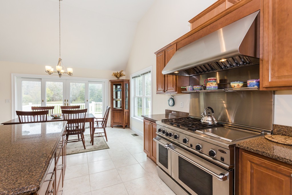 59 Ferry Road Salisbury, MA 01952 - Photo 5 of 30 a kitchen with a stove a cabinets and chairs