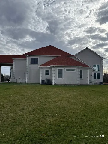 a view of a yard in front of a house with a large tree
