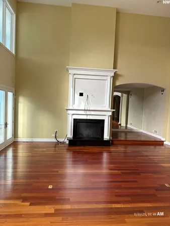 a view of empty room with wooden floor and fireplace