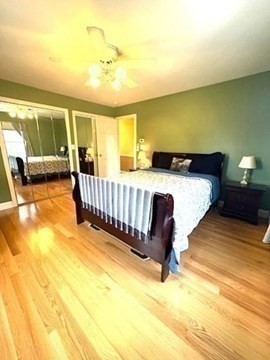 71 Old Amesbury Line Road Haverhill, MA 01830 - Photo 16 of 40 a bed sitting in a bedroom next to a larger window with wooden floor