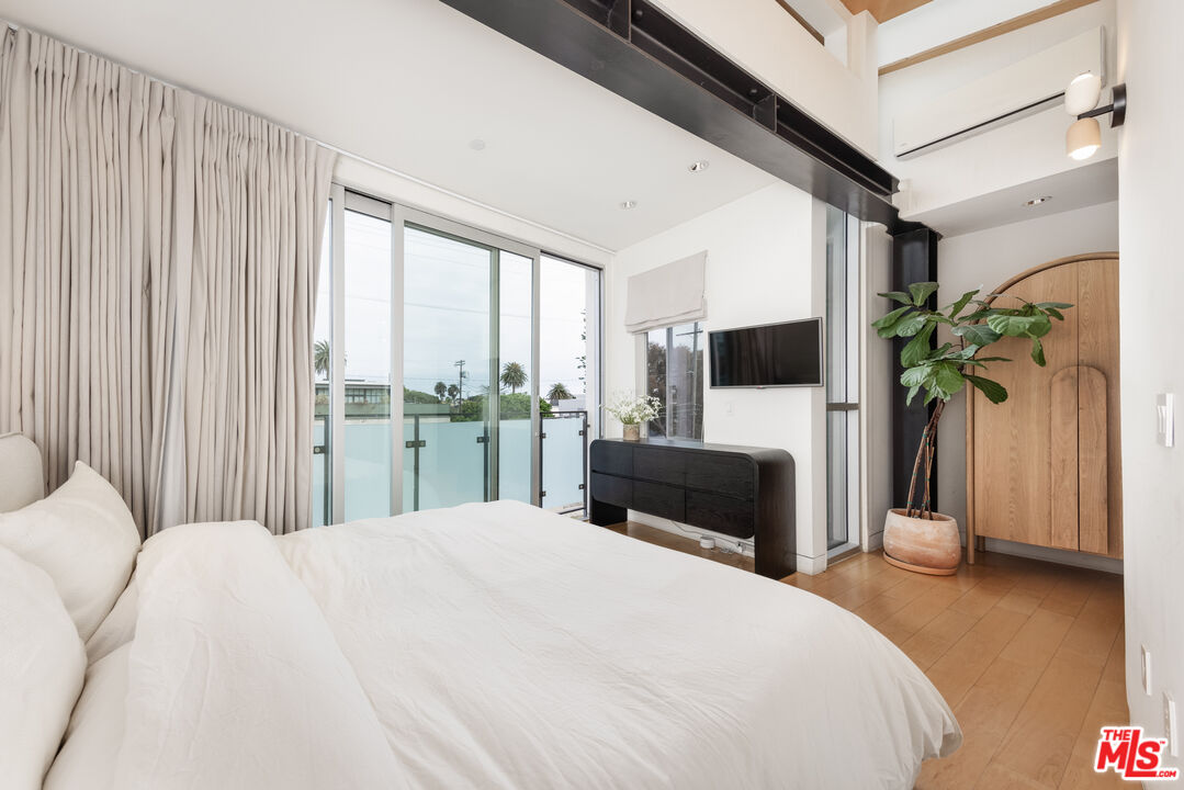 351 Sunset Avenue, Unit 5 Venice, CA 90291 - Photo 17 of 29 a bedroom with a bed flat screen tv and a potted plant