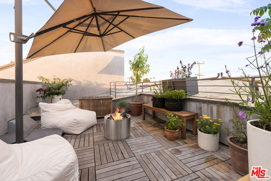351 Sunset Avenue, Unit 5 Venice, CA 90291 - Photo 23 of 29 a view of a roof deck with table and chairs potted plants