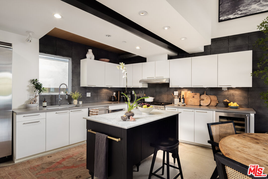 351 Sunset Avenue, Unit 5 Venice, CA 90291 - Photo 5 of 29 a kitchen with a sink stools a counter space and cabinets