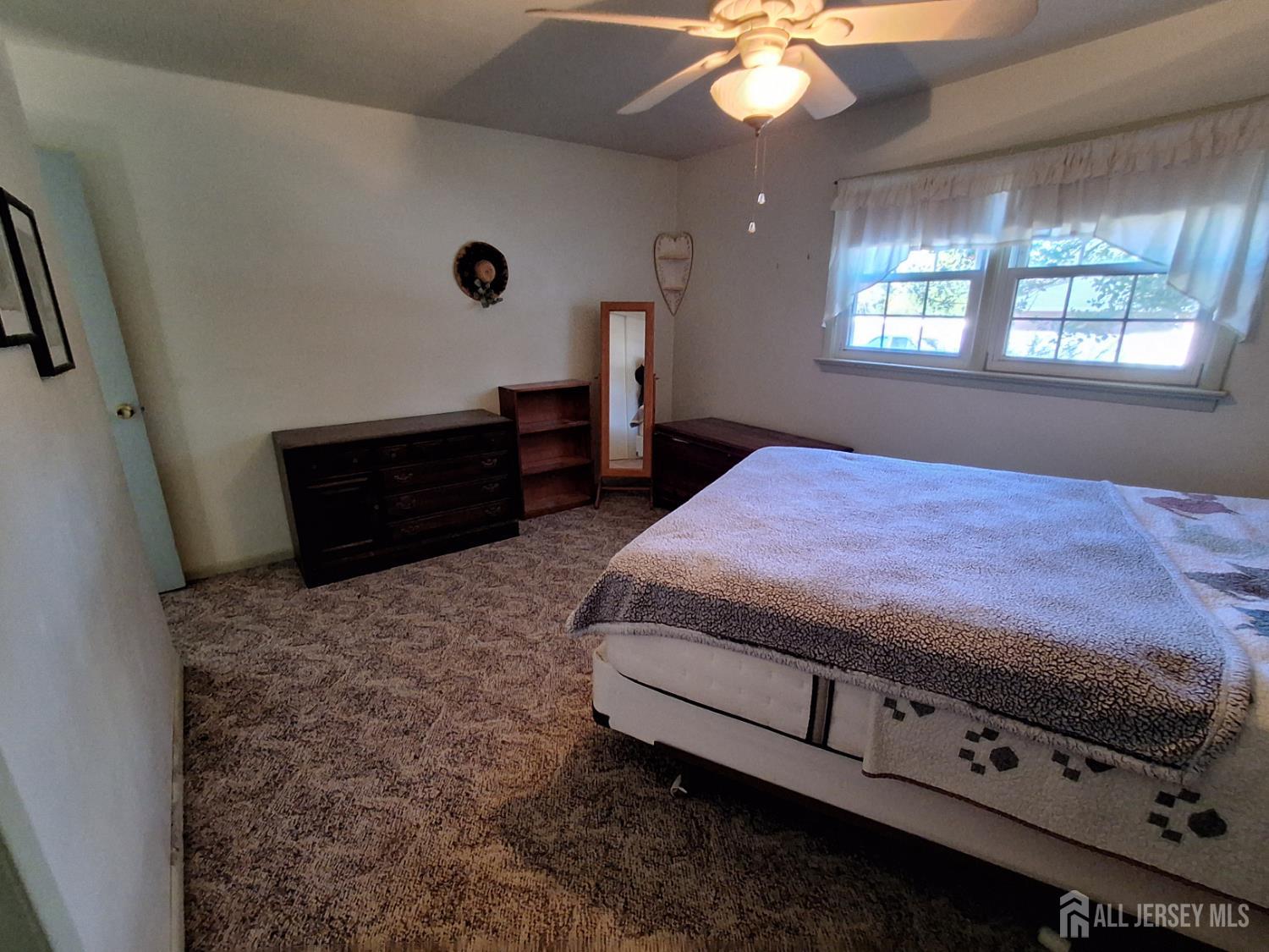 6 Nicholas Court Milltown, NJ 08850 - Photo 22 of 30 a bedroom with a bed and a chandelier