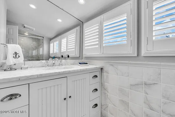 a bathroom with double sink and a mirror