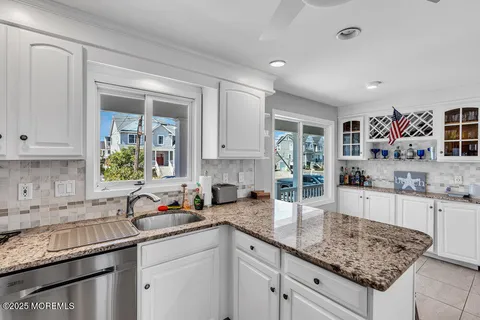 a kitchen with granite countertop a sink a stove and cabinets