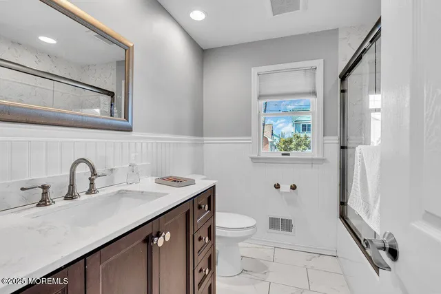 a bathroom with a sink a toilet and a mirror