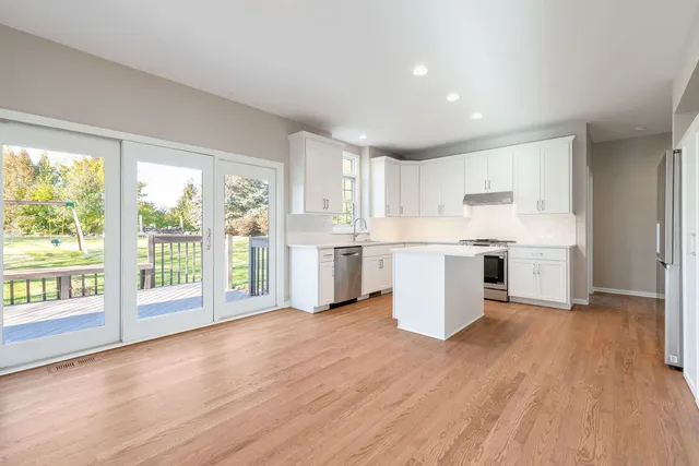 a kitchen with granite countertop white cabinets and white appliances