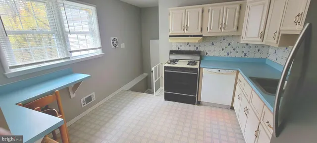 a kitchen with stainless steel appliances cabinets a sink and a window
