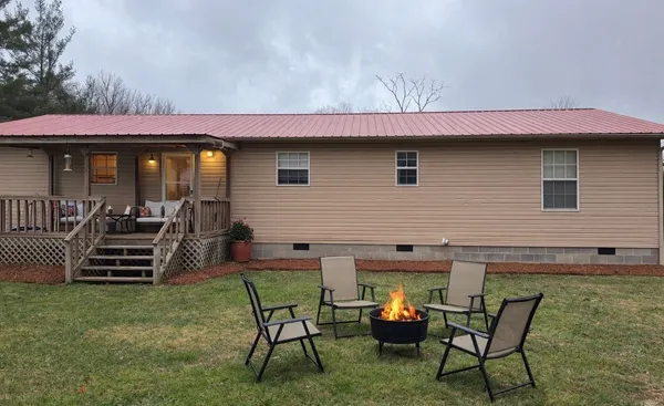 a backyard of a house with table and chairs