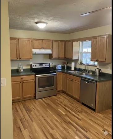 a kitchen with stainless steel appliances granite countertop a stove a sink dishwasher and a refrigerator