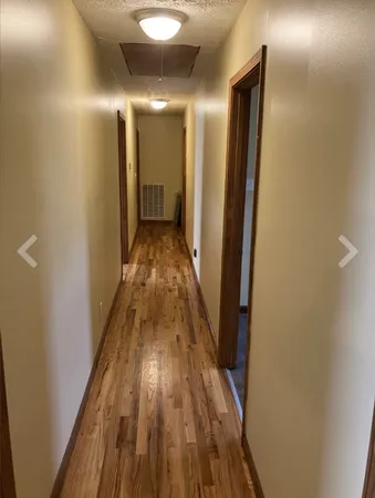 a view of a hallway with wooden floor