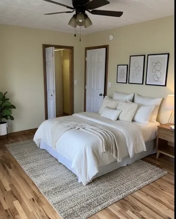 a bedroom with a bed and painting on the wall