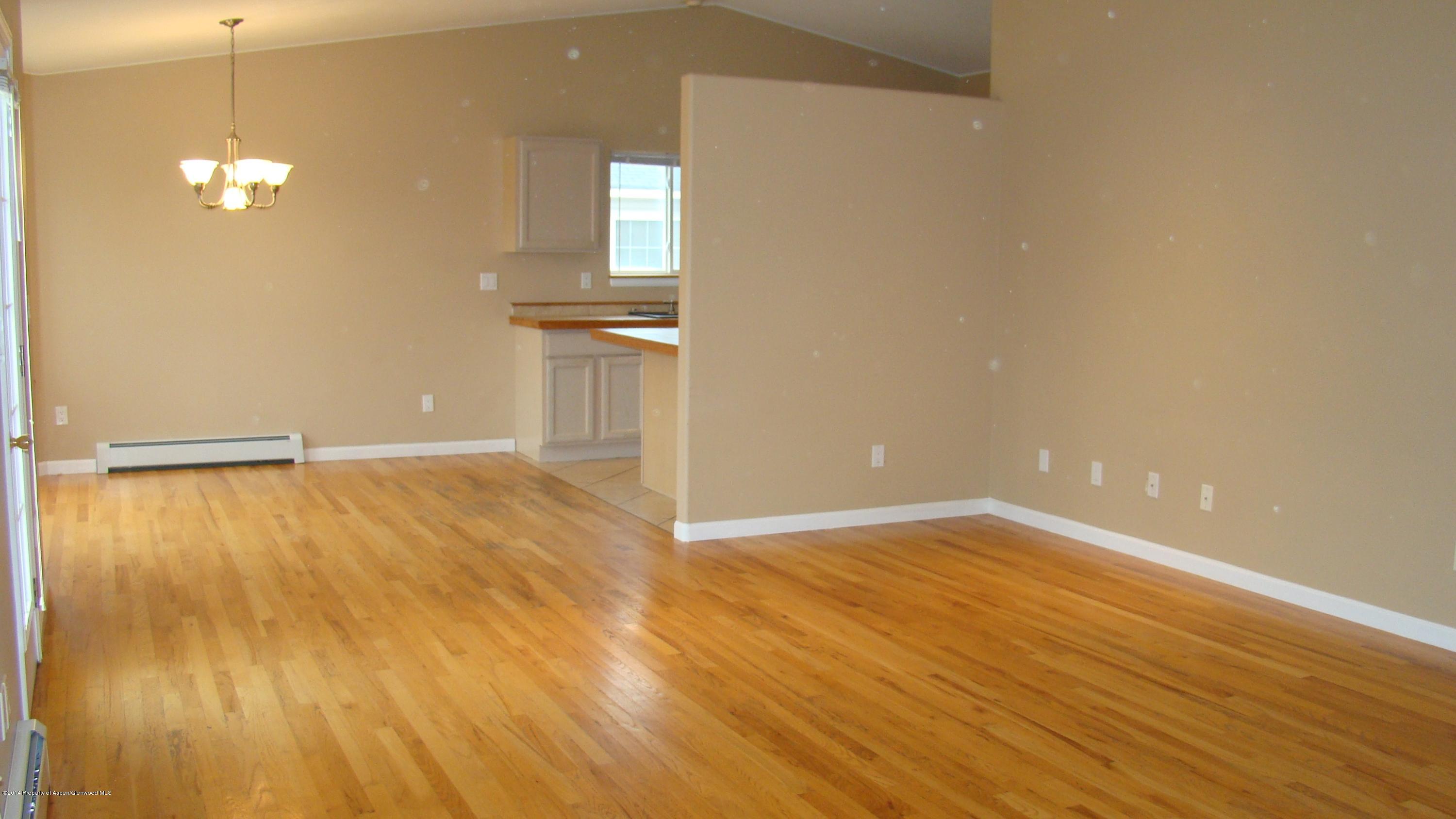 1462 Graham Court Rifle, CO 81650 - Photo 4 of 18 an empty room with wooden floor and windows